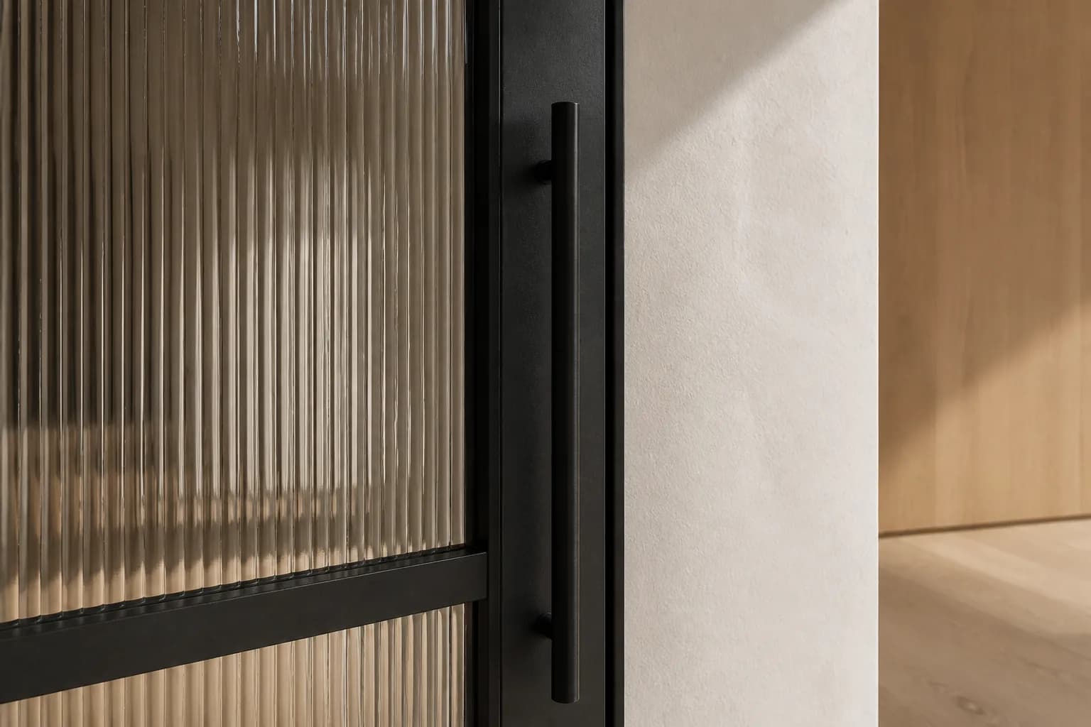 Detail van de afwerking van een stalen deur met glas